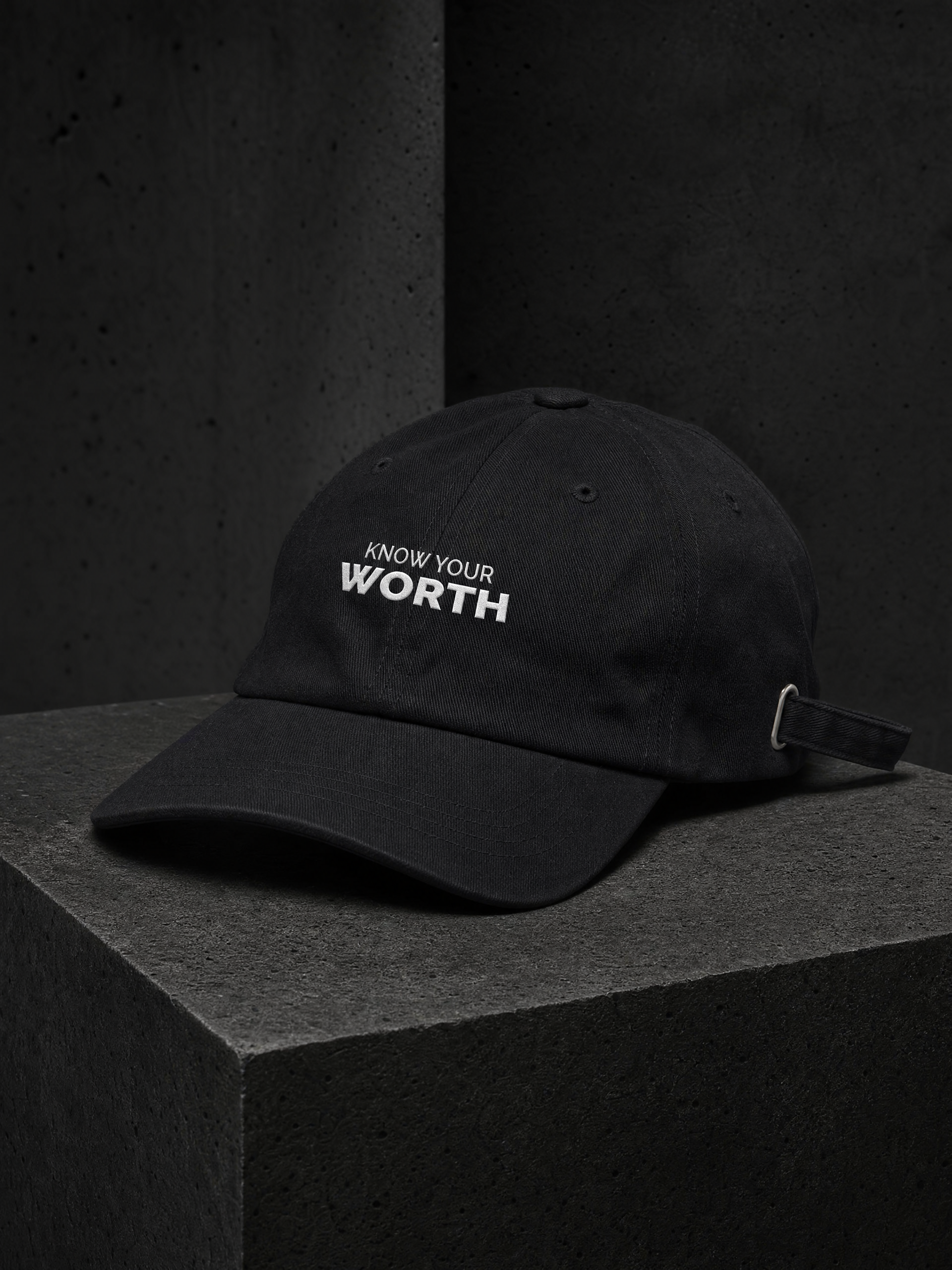 Industrial macro study of white embroidery on the black cotton twill KNOW YOUR WORTH dad cap